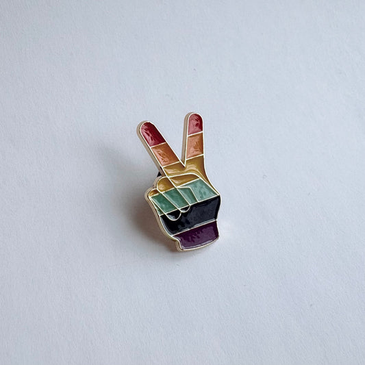 Colorful peace sign pin on a light gray background